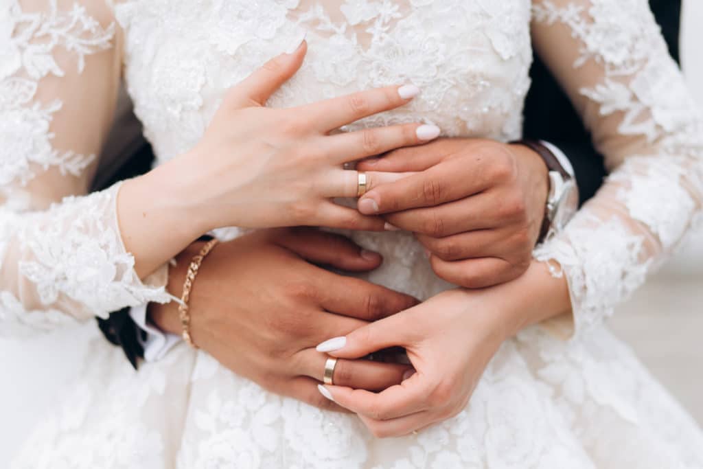 Der besondere Moment: Bräutigam und Braut setzen die Eheringe auf - Eine Vorderansicht der Hände