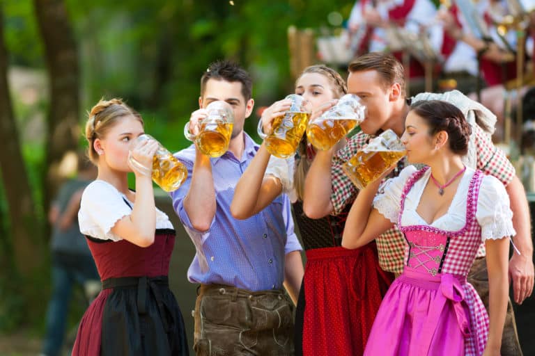 Fröhliche Freunde in traditioneller bayerischer Tracht genießen Bier auf dem Oktoberfest, buche dein Fotoshooting am Oktoberfest mit LET IT CLICK
