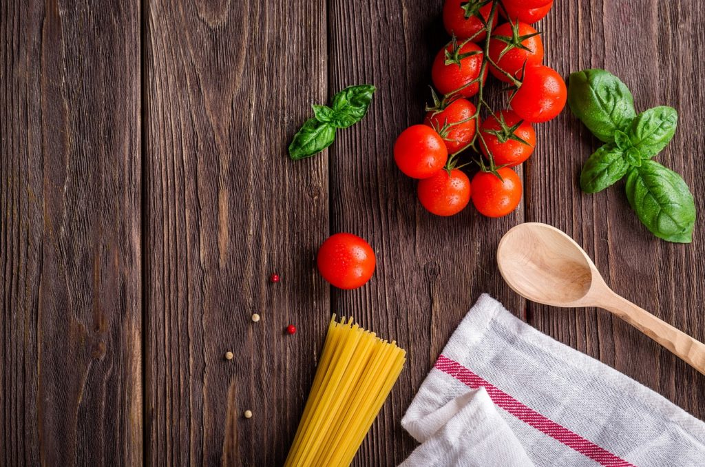 Food Fotografie : Tomaten, Spaghetti, Basilikum mit Kochutensilien auf Holz