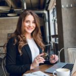 Praktikum bei LET IT CLICK als Sales und Business Developer: Engagierte Frau in Businesskleidung mit Laptop und lächelndem Gesicht