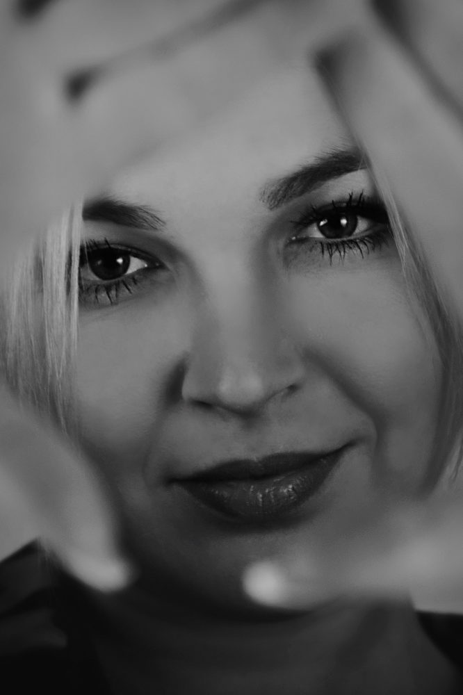 Kreatives Portraitfoto: Frau in schwarzweiß mit Händen als Rahmen. Fotostudio Quakenbrück