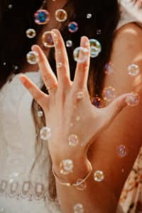 Magischer Moment beim JGA - Hand mit Schmuck umgeben von Seifenblasen, festgehalten von LET IT CLICK