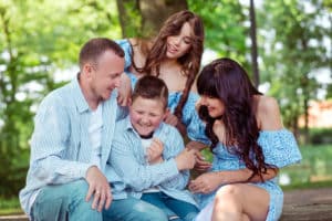 Lustiger Moment beim Familienfotoshooting im Park: Eltern und Kinder genießen die gemeinsame Zeit.