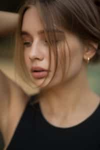 Mädchen mit goldenen Ohrringen und elegantem Ausdruck im Gesicht.