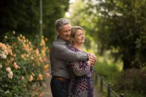 Herzliche Aufnahme eines Ehepaares beim Familien-Fotoshooting, umarmend und lächelnd, umgeben von einer warmen und liebevollen Atmosphäre. LET IT CLICK