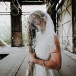 Natürliches Portrait einer Frau, die in einem der grünen Parks von Köln sitzt, umgeben von lebhafter Natur und belebter Stadtatmosphäre