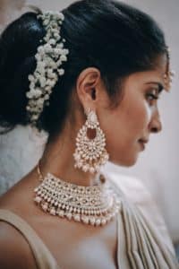 Romantisches Hochzeitspaar spaziert Hand in Hand über die Hohenzollernbrücke in Köln, mit Liebe und Freude in einem professionellen Fotoshooting eingefangen.