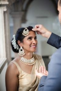 Braut und Bräutigam lächeln glücklich während ihres Hochzeitsshootings vor dem historischen Kölner Dom, strahlende Sommerhochzeit in Köln.