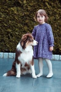 Ein Kind posiert mit einem Hund während eines Tiershootings.