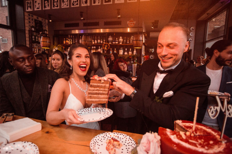Der Bräutigam serviert seiner Braut einen köstlichen Kuchen während der Feier nach der standesamtlichen Trauung in Münster. Eine Atmosphäre der Freude und des Glücks liegt in der Luft.