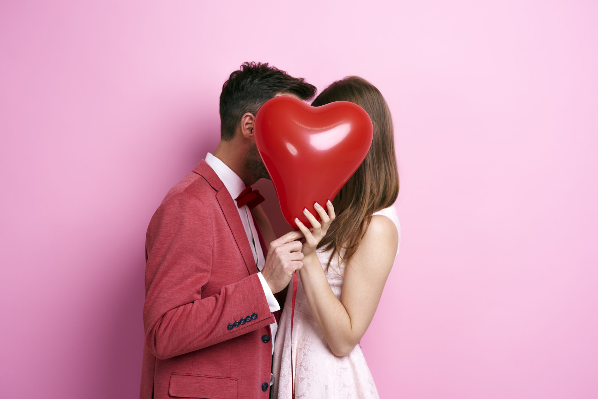 Ein verliebtes Paar haltet gemeinsam ein großes, dekoratives Herz, symbolisch für die Romantik und Verbundenheit des Valentinstags, umgeben von einer stimmungsvollen und liebevollen Atmosphäre.