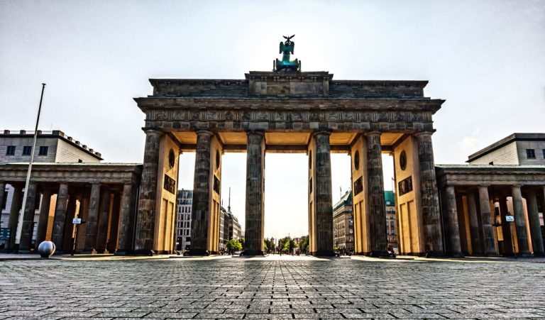 Das Brandenburger Tor in Berlin unter einem grauen, wolkenverhangenen Himmel. .