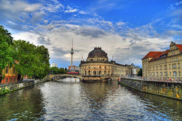 Ein Blick auf die Spree in Berlin mit dem markanten Bodemuseum im Hintergrund. Dahinter ragt der Fernsehturm in den Himmel.