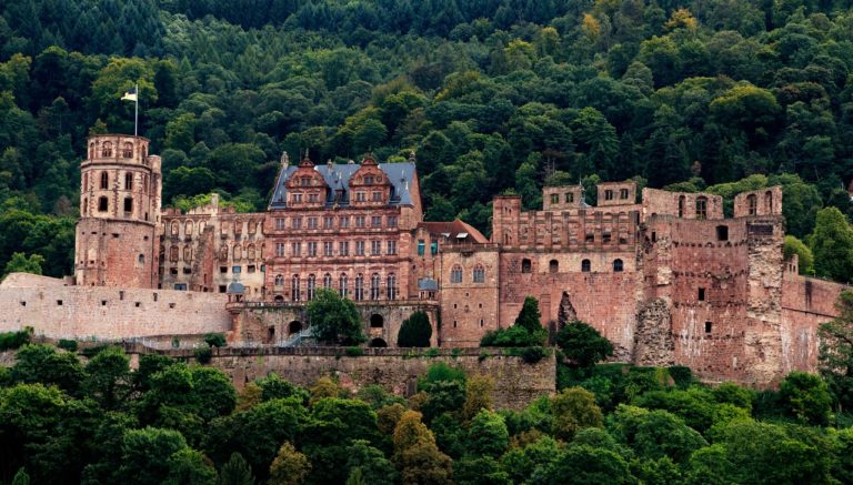 Schloss Heidelberg thront majestätisch über der Altstadt, umgeben von grünen Hügeln. Die eindrucksvollen Ruinen und die malerische Lage am Neckar machen es zu einem beliebten Fotomotiv und einer der romantischsten Burgen Deutschlands