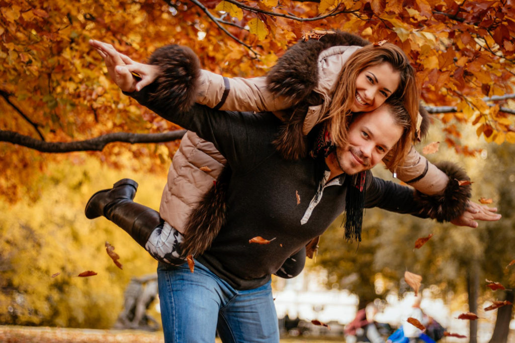 Pärchenshooting im Herbst: Glückliches Paar genießt den Herbst im Freien, während eines professionellen Outdoor-Fotoshootings mit buntem Laub